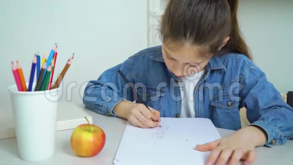 穿牛仔裤的女生穿着彩色铅笔画画吃苹果视频的预览图
