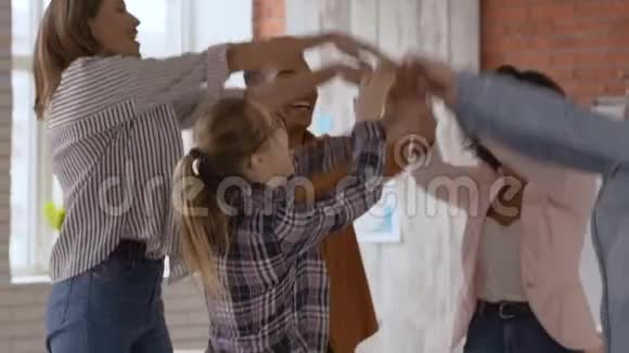 不同的商业人士跳舞兴奋地庆祝成功的公司创业快乐的同事欢呼的手臂举起视频的预览图