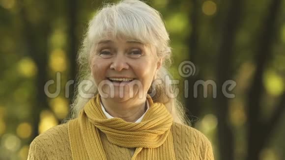 微笑着的老妇人摆着相机挥舞着手与安全的老人一起快乐视频的预览图