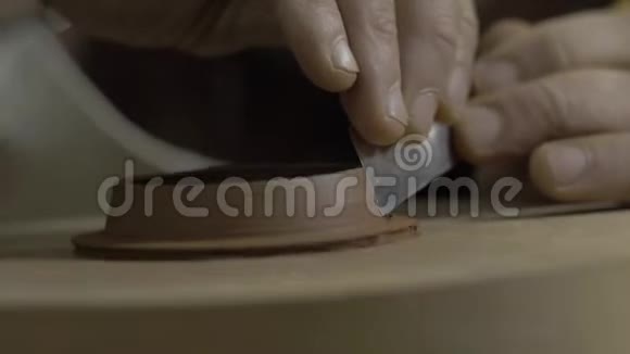 主人用金属工具从宜兴粘土中取出茶壶盖子上多余的粘土茶叶手工粘土茶壶视频的预览图