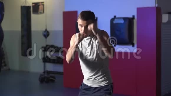 拳击手训练在健身房向摄像机投掷拳头影子在缓慢运动中战斗视频的预览图
