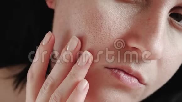 女人脸特写女孩触摸问题皮肤的手指毛孔扩大检查它概念视频的预览图
