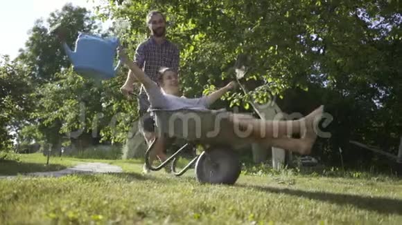 年轻的幸福夫妇玩得很开心骑着乡村手推车视频的预览图