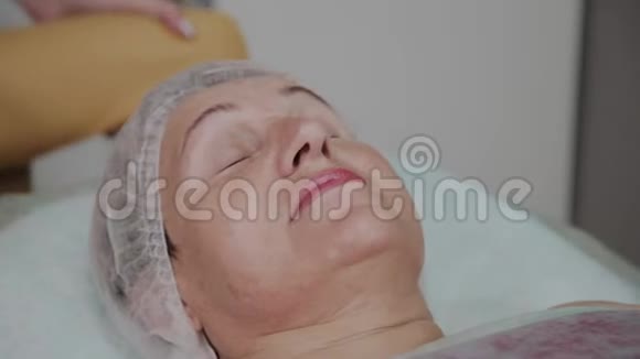 美容师在美容诊所给一位老年妇女卸妆视频的预览图