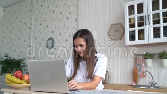 女孩在笔记本电脑上工作在电子邮件中得到积极的消息感到快乐兴奋慢动作视频的预览图