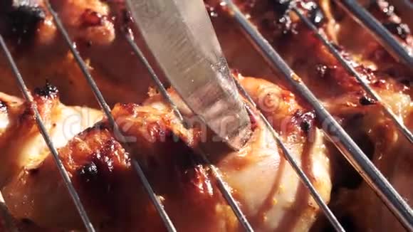 皮塞斯一只炸鸡用刀子检查烤架上的肉是否准备好视频的预览图