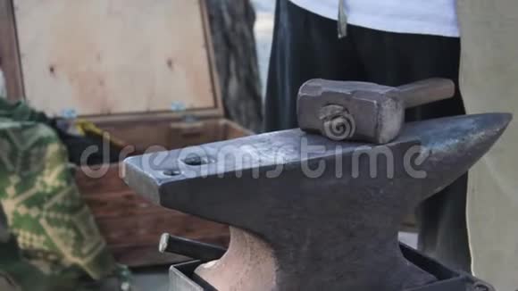 在工业中铁匠用铁锤敲击铁锤并产生炽热的火花在铁匠后面视频的预览图