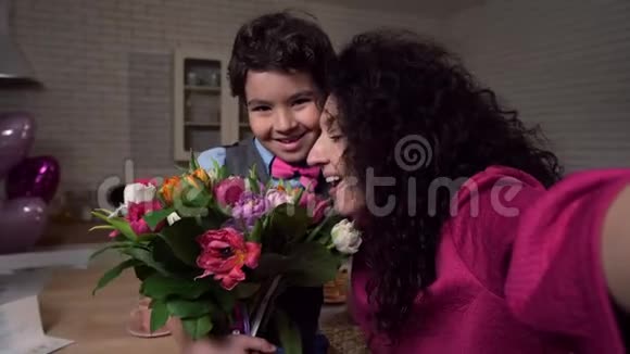 快乐妈妈和儿子抱着鲜花自拍视频的预览图