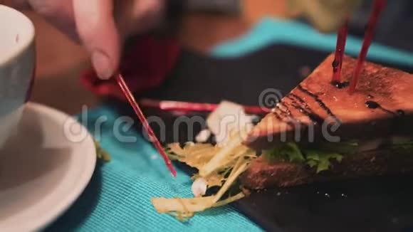 女孩在咖啡馆里吃塑料串漂亮的三明治快关门美味的食物视频的预览图