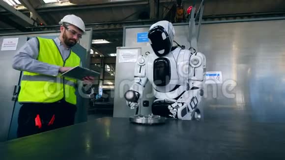 工厂工人正在控制一个半机器人抛光金属圆盘视频的预览图