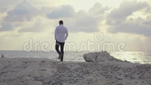 年轻人走在海滩上欣赏着令人惊叹的海滨景色和美丽的天气塞浦路斯帕福斯视频的预览图