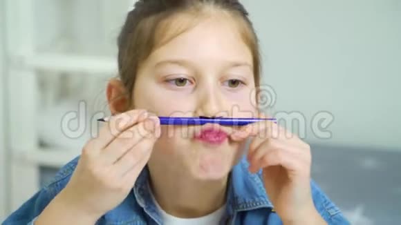 校园女孩玩得很开心用彩色铅笔做小胡子视频的预览图