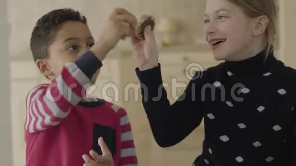 可爱的非裔美国男孩和金发白种人女孩蓝眼睛在厨房里玩耍小朋友打架视频的预览图