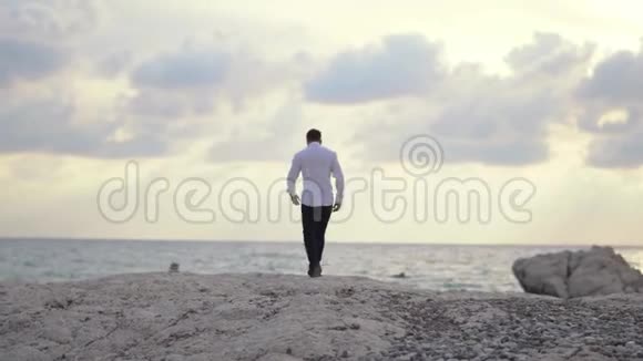 年轻人走在海滩上享受着令人惊叹的海滨景色塞浦路斯帕福斯视频的预览图