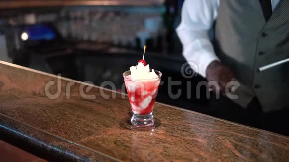 酒保在柜台上用熔岩流鸡尾酒装饰玻璃杯视频的预览图