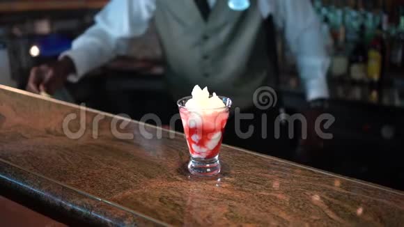 酒保在柜台上用熔岩流鸡尾酒装饰玻璃杯视频的预览图