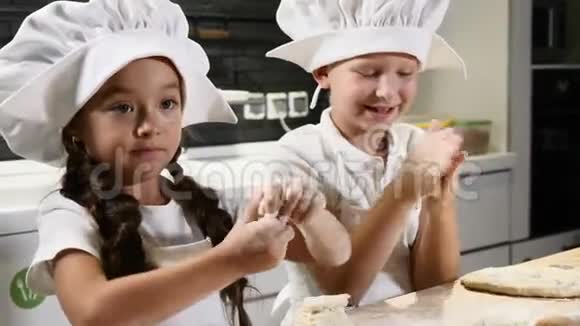 小孩子们拿面团擀面杖和面粉当酋长56岁围裙和厨师帽视频的预览图