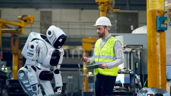 男工正在向一个机器人发出指令视频的预览图