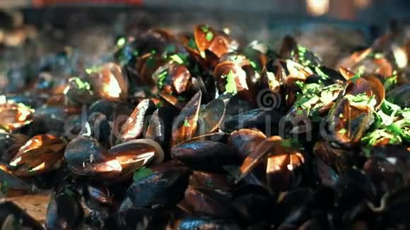 特写贻贝与草药烹饪在煎锅上蛤蜊在露天烧烤视频的预览图