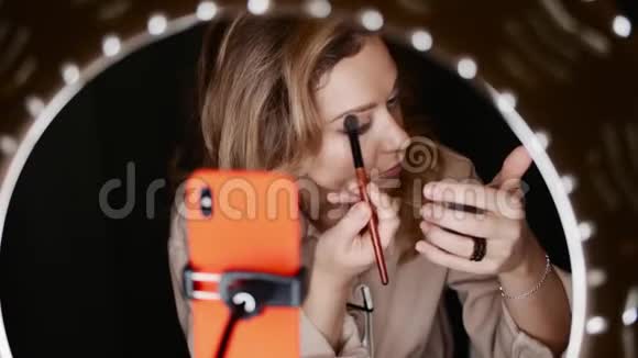 漂亮的女化妆师将眼影放在眼前灯光下视频的预览图