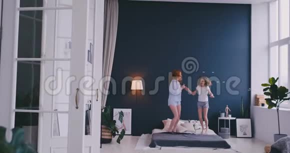 可爱的小女孩和她可爱的母亲一起玩跳舞现代风格一起跳在床上给高五视频的预览图
