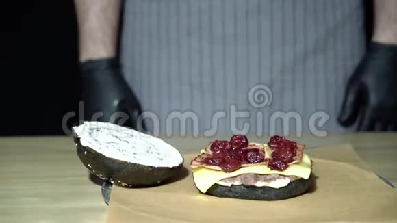 做汉堡美味的黑汉堡有切肉熏肉奶酪和樱桃酱视频的预览图