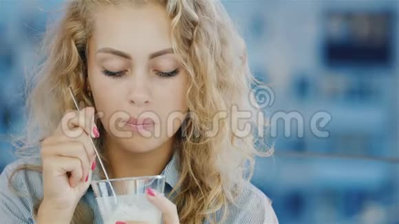 一位年轻的女商人在露台上的咖啡馆里吃冰淇淋的画像视频的预览图