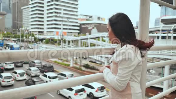 一个忧郁悲伤的印尼女孩注视着雅加达市中心一座桥上的交通视频的预览图