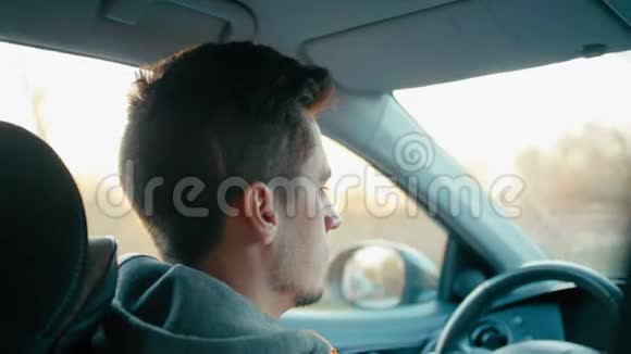 从后视中近距离拍摄的年轻白人驾驶汽车视频的预览图