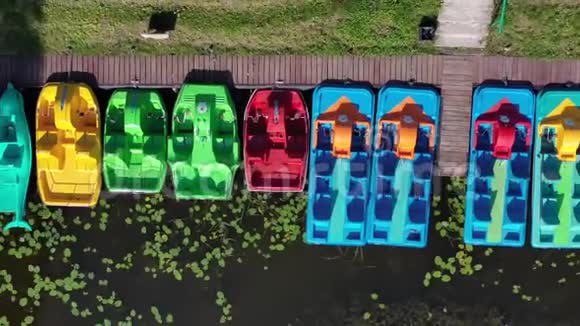 彩色塑料脚踏船群和湖岸码头视频的预览图
