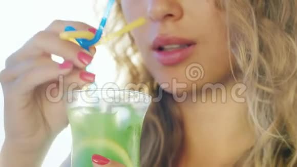 性感女人从管子里喝鸡尾酒在镜框中的特写镜头只能看到嘴唇与视频的预览图
