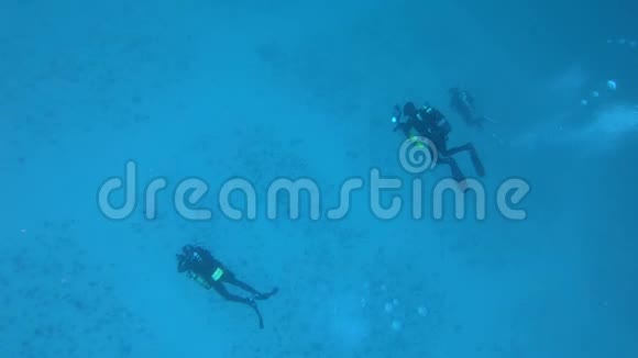 水下运动三名潜水者在沙底视频的预览图