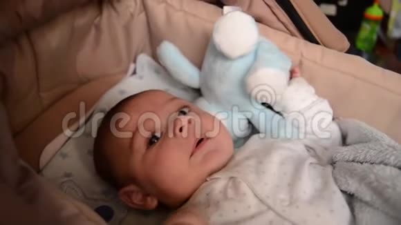 可爱的3个月大的男孩在婴儿床上做滑稽的表情视频的预览图