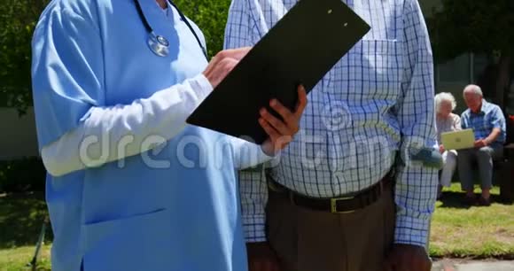 积极的亚洲老年男女医生在花园里讨论医疗报告的正面看法视频的预览图