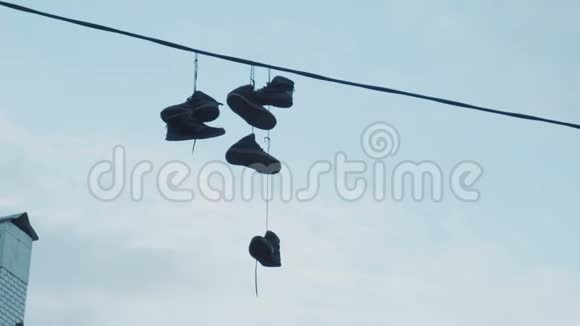 三双运动鞋挂在九米高的城市街道上的电线上视频的预览图