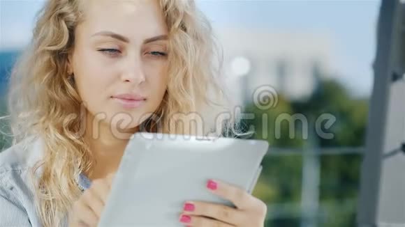 一位迷人的年轻女子的肖像使用平板电脑在咖啡馆的夏季区域微笑积极的情绪视频的预览图