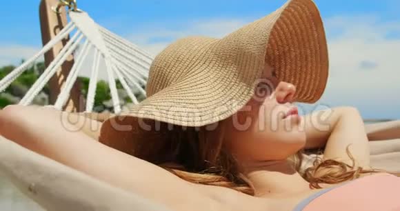 在海滩4k的吊床上放松的高加索女人的正面景色视频的预览图