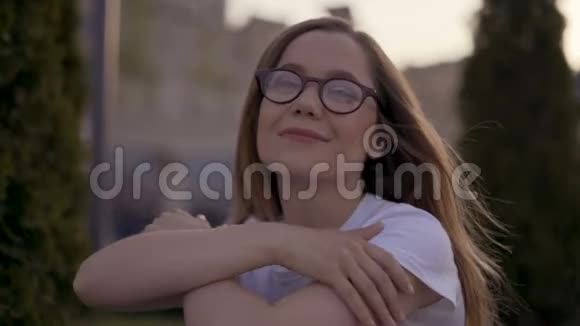 特写肖像戴眼镜的女孩坐在公园的草地上视频的预览图