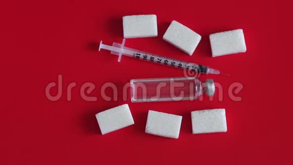 含有胰岛素的胰岛素注射器放在红色背景的精制糖块上视频的预览图