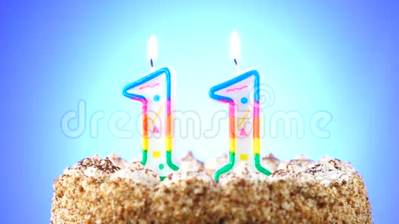 用燃烧的生日蜡烛做生日蛋糕第11号背景变化颜色视频的预览图