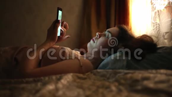 互联网和休闲一位年轻女子正在床上休息和上网视频的预览图