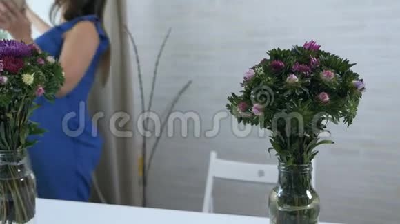 一个在家的小女孩把花束放进一辆装满水的手推车里视频的预览图
