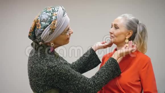 两位高级妇女在见面时炫耀新耳环和珠宝饰品视频的预览图