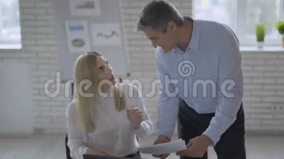 男人和女人的同事正在使用笔记本电脑聊天分享现代办公室的商业想法女孩坐在书桌前视频的预览图