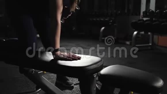 运动的年轻女子在健身房举重在长凳上举重锻炼晚上训练快关门视频的预览图