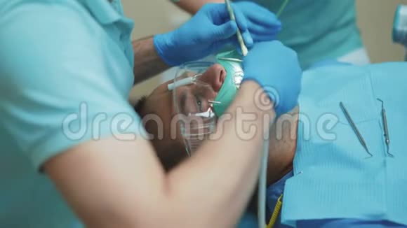 牙科医生在诊所用牙钻治疗病人牙齿4K视频的预览图