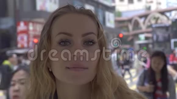 幸福的女人在现代城市街头背景下寻找镜头脸上有雀斑的漂亮女人微笑着摆姿势视频的预览图