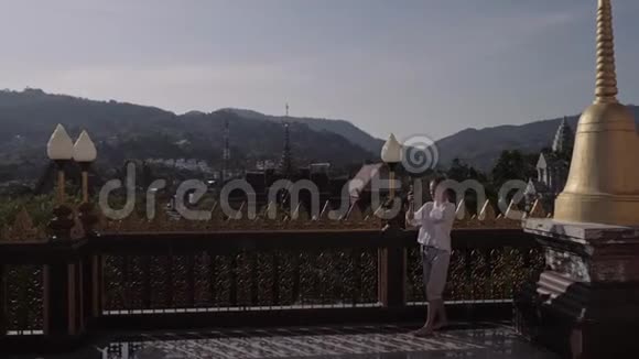 泰国佛寺青年游客用手机拍照视频的预览图