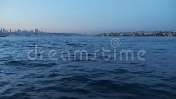 从船上眺望黄昏深蓝色的海浪拍打着城市视频的预览图