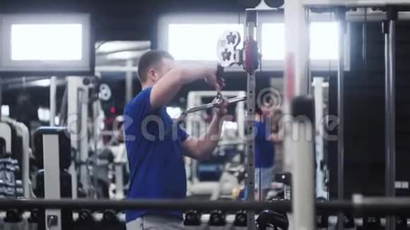 在健身房锻炼手臂前男人要调整三头肌视频的预览图
